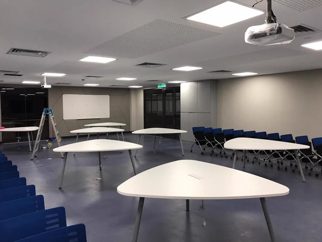 Lecture room with ceiling-mounted projectors and group tables
